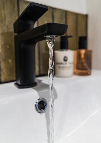 a stream of water coming out of a faucet at Priory Bay Escapes - Uminari in Tenby