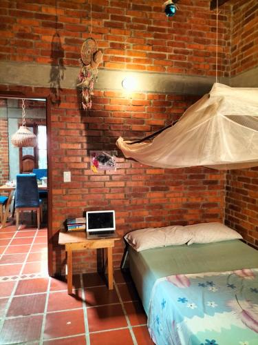 a bedroom with two beds and a brick wall at Habitación privada in Santa Marta