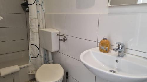 ein Badezimmer mit einer weißen Toilette und einem Waschbecken in der Unterkunft Green Apartment Studio L30 Neukölln in Berlin