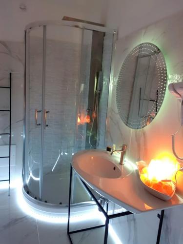 a bathroom with a sink and a shower with a mirror at B&B Da Me in Crotone