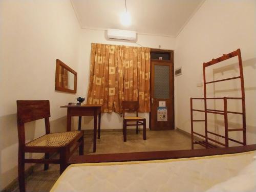 um quarto com uma mesa e cadeiras e um espelho em Waves em Hikkaduwa