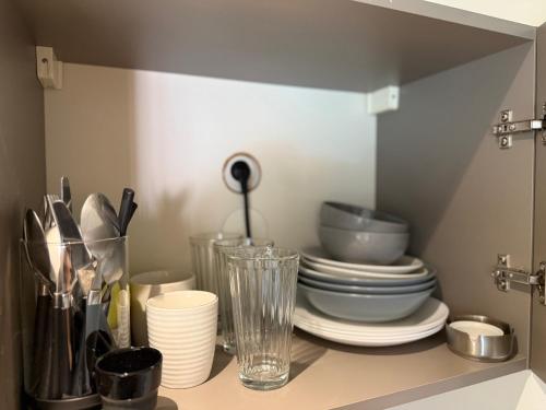 ヴィルールバンヌにあるStudio charmettesの皿やボウル、その他の台所用品が入った食器棚