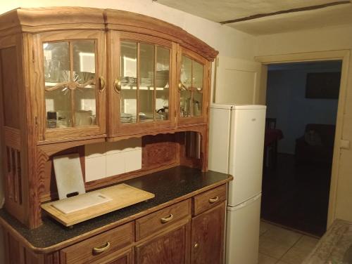 a kitchen with a wooden cabinet and a refrigerator at Ferienhaus Lehmhaus in Häven