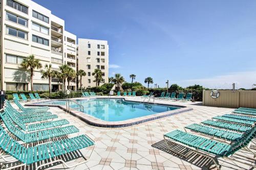 a swimming pool with lounge chairs next to a building at Amelia Surf and Racquet Club Condo - 1st Floor Ocean View - Pools - Tennis Courts - Sleeps 4 in Fernandina Beach