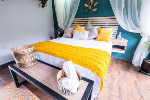 a bedroom with a large bed with a yellow blanket at Cabaña de lujo en la montaña in Santa Marta