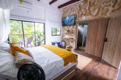 サンタ・マルタにあるCabaña de lujo en la montañaのベッドと大きな窓のある寝室