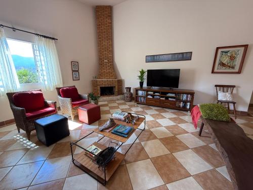 a living room with a couch and a fireplace at Pousada e Chalés Passaredo Canastra in São Roque de Minas