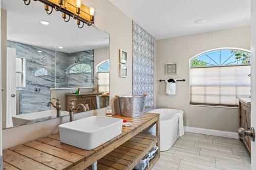 un bagno con un grande lavandino, una vasca e un lavandino di 6 Bedrooms 4 Bath with sand and heated pool a Clearwater Beach