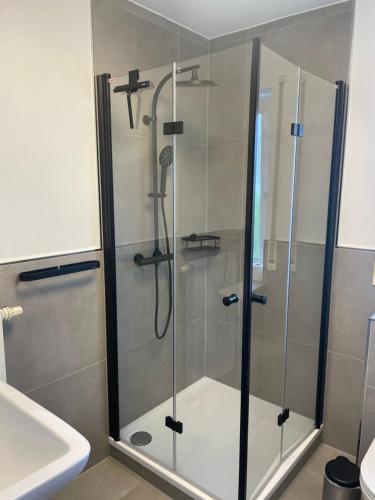 a shower with a glass door in a bathroom at Eastside - Apartment WHG 02 in Senftenberg
