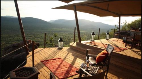 a wooden deck with a table and a laptop on it at Saruni Samburu in Archers Post