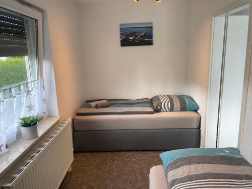a small bedroom with a bed and a window at Eastside - Apartment WHG 02 in Senftenberg