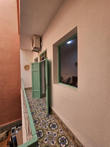 a hallway with a green door and a mirror at 里院 Daoudiate courtyard in Marrakech