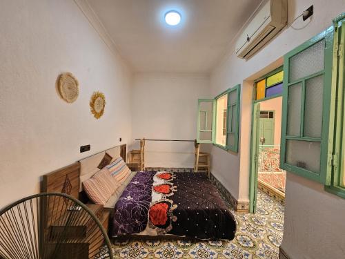 a bedroom with a bed and a couch and windows at 里院 Daoudiate courtyard in Marrakech