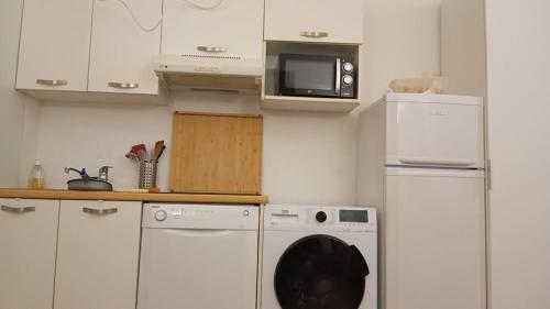 a kitchen with a washing machine and a microwave at Résidence la Citadelle in Saint-Florent
