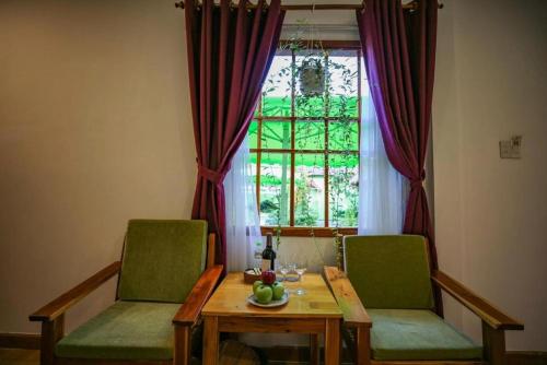 einem Esstisch mit 2 Stühlen und einem Fenster in der Unterkunft Bamboo Resort Phu Quoc in Phu Quoc