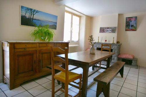 uma sala de jantar com uma mesa de madeira e um banco em Maison Chantina em Sainte Engrace