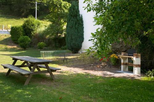 a wooden picnic table in the grass in a yard at Maison Chantina in Sainte Engrace