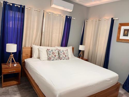 a bedroom with a large bed with blue curtains at Casa Lambí in Cabrera