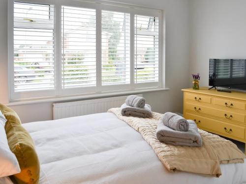 a bedroom with a bed with towels on it at Poppys' Place in Sewerby