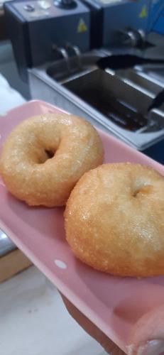two donuts sitting on top of a pink plate at Sığacık Antik Otel in Siğacık