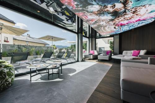 an open living room with tables and chairs at Hotel Tirol Fiss 4Sterne Superior in Fiss