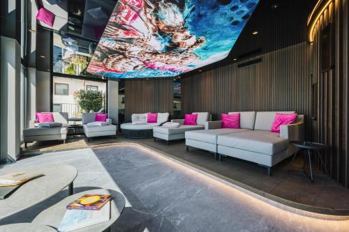 a lobby with couches and a large painting on the wall at Hotel Tirol Fiss 4Sterne Superior in Fiss