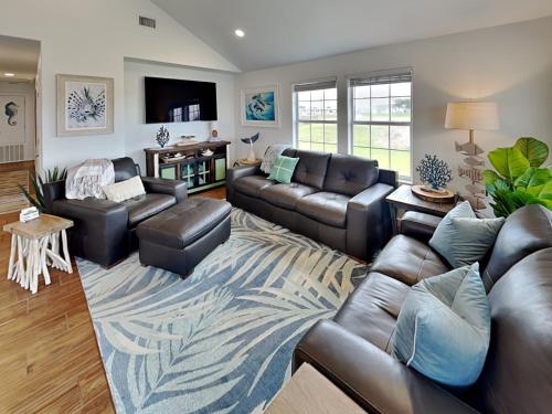 a living room with leather furniture and a rug at Inn at Dolphin Bay in Rockport