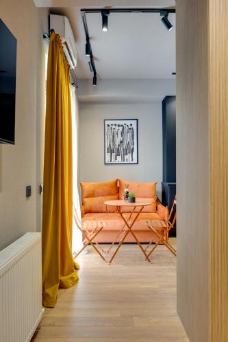 a living room with an orange couch and a table at Ninore Orange Apartment in Old Tbilisi in Tbilisi City