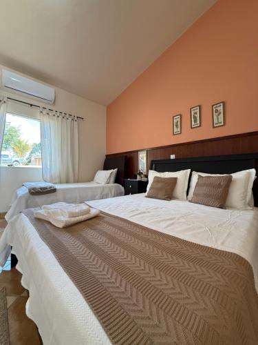 a large bedroom with two beds and a window at Pousada e Chalés Passaredo Canastra in São Roque de Minas