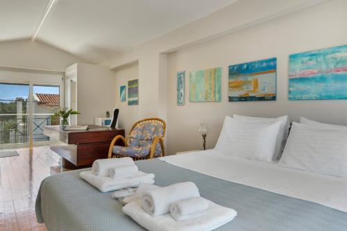 een slaapkamer met een groot bed met handdoeken erop bij Beach Family Villa in Artemida in Artemida
