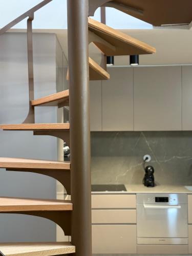 a staircase in a kitchen with white cabinets at Cantinho da Cuca - Gerês in Terras de Bouro