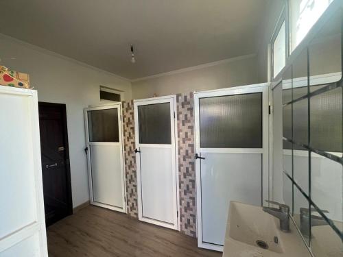 ein Badezimmer mit drei Türen und einem Waschbecken in der Unterkunft Villa Authentique piscine privée in Kenitra
