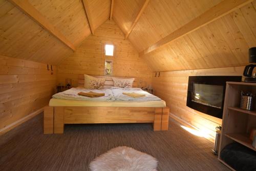 a bedroom with a bed in a wooden cabin at Zittau - Ferienwohnung Frieda mit Camping Familien, und Biker Hütten am Zittauer Gebirge in Zittau