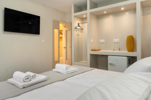een slaapkamer met een groot wit bed met twee handdoeken bij Beach Family Villa in Artemida in Artemida