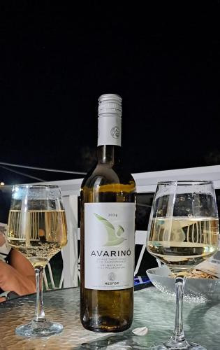 a bottle of wine and two glasses on a table at Ionian Boutique Apartments - Corfu Seaside Getaways in Agios Georgios