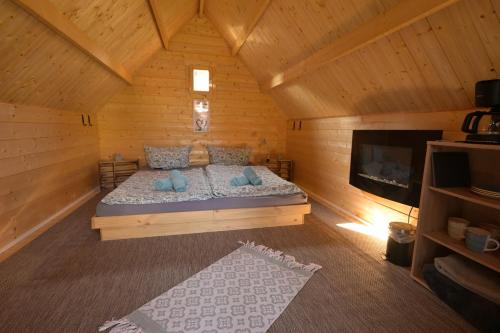 a bedroom with a bed in a wooden cabin at Zittau - Ferienwohnung Frieda mit Camping Familien, und Biker Hütten am Zittauer Gebirge in Zittau