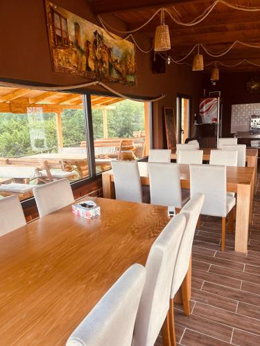 a dining room with a wooden table and white chairs at Petrovf Place 