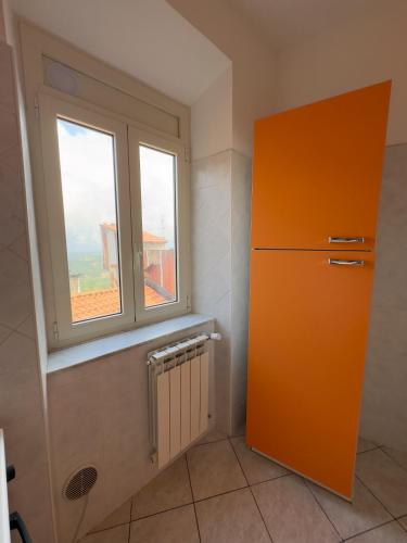 a kitchen with an orange refrigerator and a window at La Terrazza Sulla Valle in Sgurgola