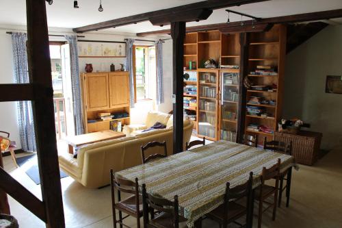 a living room with a table and a couch at Le moulin de vaux in Nochizé