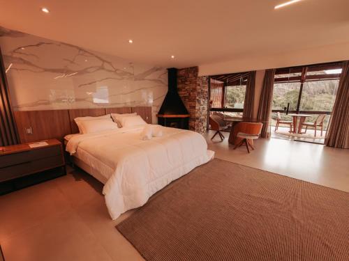 a bedroom with a large bed with a stone wall at Turisfri Resort in Nova Friburgo