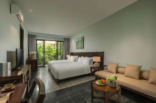 a living room with a bed and a couch at Coco Island Resort Ninh Binh in Ninh Binh