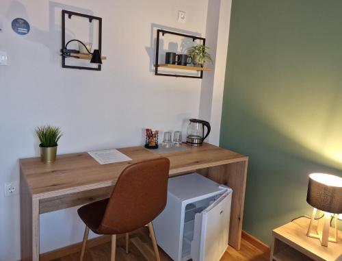 a wooden desk with a computer and two chairs at Apartmani i sobe PARK in Apatin