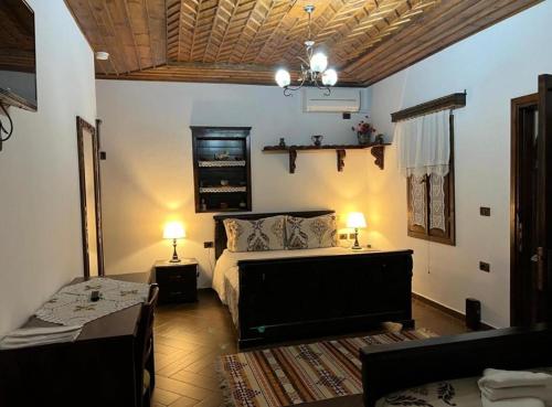 a bedroom with a bed and a couch in a room at Hotel Kaceli in Berat