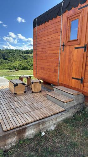 a wooden cabin with a door and benches on a deck at Petrovf Place 