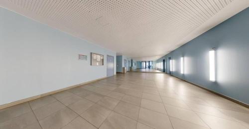an empty hallway with blue walls and a tile floor at chambre avec salle de bain privée au cœur de La Défense in Nanterre