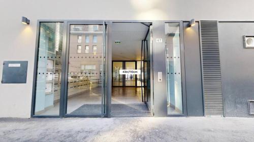 an entrance to a building with glass doors at chambre avec salle de bain privée au cœur de La Défense in Nanterre