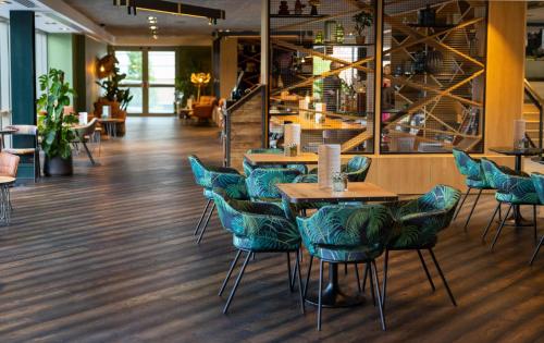 a restaurant with blue chairs and tables at voco Leicester by IHG in Leicester