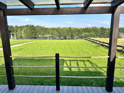 a view of a large field from a porch at Oaza Żuraw in Miłki