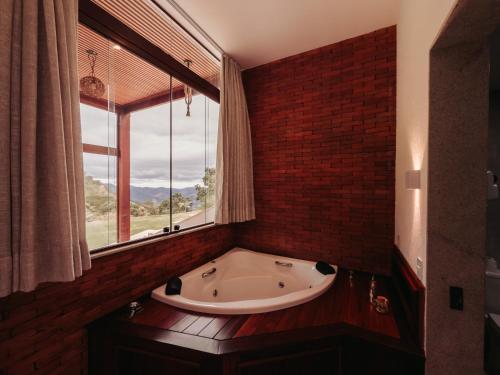 a bath tub in a room with a window at Turisfri Resort in Nova Friburgo