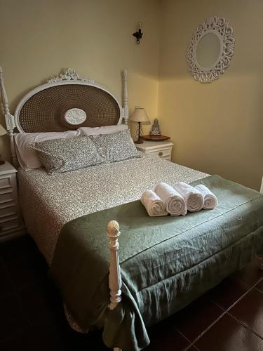 a bedroom with a bed with two rolled towels on it at Casa da Forja - Gerês in Gondoriz